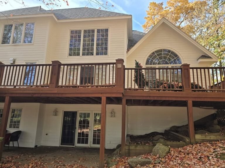 Deck pre-staining inspection in progress two story home